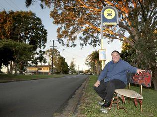 Cr Reece Byrnes admires a Local Artists attempt to provide public seating for Bilambil Heights commuters. It is constructed from two half surfboards, a snowboard and all mounted on the frame of an old wheelchair. Picture: Richard Mamando