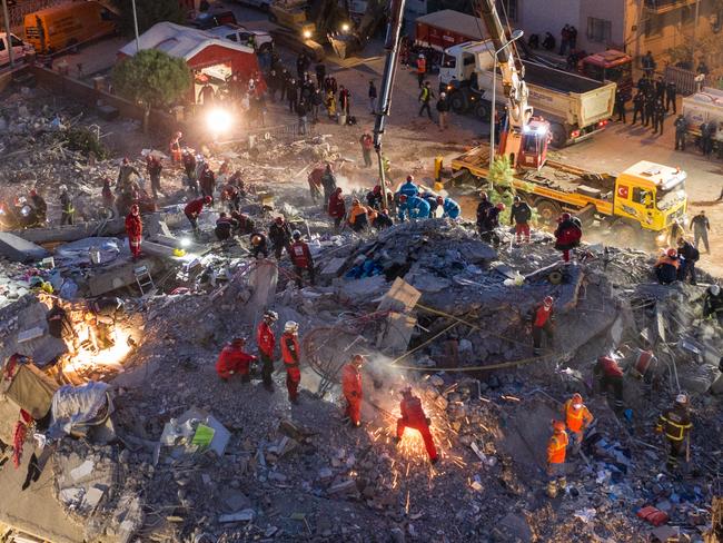 IZMIR, TURKEY - OCTOBER 31:  Emergency services personnel search a collapsed building for survivors the day after a powerful earthquake struck on October 31, 2020 in Izmir, Turkey. Twenty-four people have been killed and more than eight hundred injured after an earthquake struck the Aegean Sea off the coast of Turkey's Izmir Province. More than twenty buildings were destroyed in Izmir, Turkey's third largest city. (Photo by Burak Kara/Getty Images)