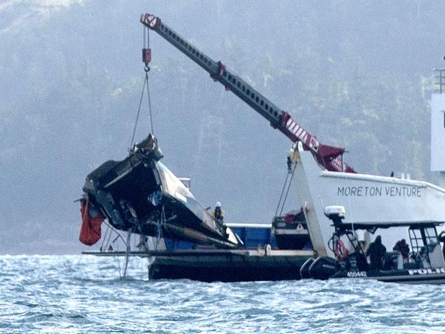 The sad image of a crane lifting the wreckage of a MRH-90 military helicopter in the Whitsundays. The helicopter crashed with four Australian servicemen on board on July 29. Picture: Michaela Harlow