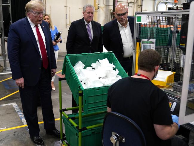 Donald Trump watches masks being made as he participates in a tour of a plant that manufactures personal protective equipment in Phoenix. Picture: AP