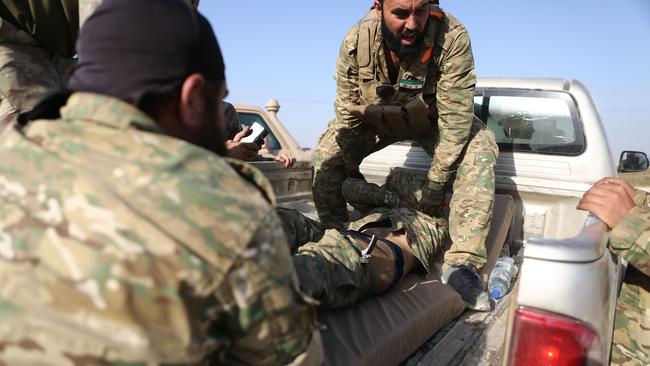 Turkish-backed Syrian fighters evacuate a wounded comrade near the border town of Ras al-Ain, as Turkey and it's allies continued their assault on Kurdish-held border towns in northeastern Syria. Picture: AFP