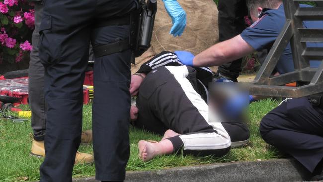 A person in handcuffs on Peter St in Grovedale. Picture: Satria Dyer-Darmawan