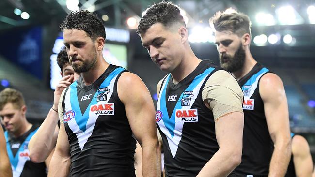 Travis Boak and Tom Rockliff look dejected as they lead their Power teammates from the field after Saturday’s night’s big loss to the Kangaroos at Marvel Stadium. Picture: Getty Images