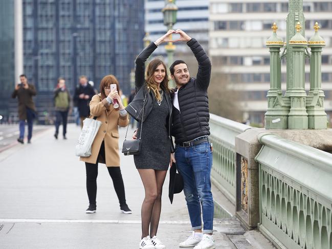 People pose for photographs on Westminster Bridge in central London on March 23, 2017 after the bridge reopened to traffic following its closure during the March 22 terror attack. Picture: AFP