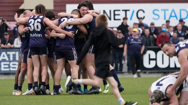 Edithvale-Aspendale players celebrate, while Chelsea captain Todd Gardiner is consoled by opponent Brad Tagg. Picture: Valeriu Campan