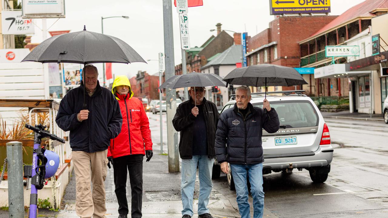 Wet weather in North Hobart. Pals Tony Beard, Tony Horsham, John Pool and Essie walk down Elizabeth Street on Friday 23rd June. Picture: Linda Higginson.