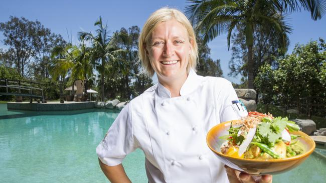 Makepeace Island executive chef Lisa Mahar by the pool holding her sticky rice Vietnamese yellow curry with crispy skin roasted chicken, fresh coconut and an asian herb salad. Picture: Lachie Millard