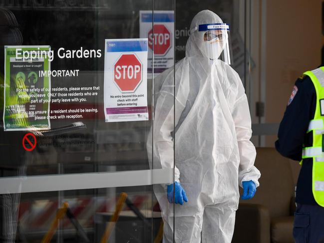 Medical workers speak at the entrance of the Epping Gardens aged care facility in the Melbourne suburb of Epping on July 29, 2020, as the city battles fresh outbreaks of the COVID-19 coronavirus. - Australia on July 30 reported a record number of new coronavirus infections and its deadliest day of the pandemic so far following a spike in cases at elderly care homes. (Photo by William WEST / AFP)