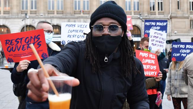 A man offers a cocktail at the “Stay open” (Restons ouverts) protest against the government's decision to close their facilities. Picture: AFP