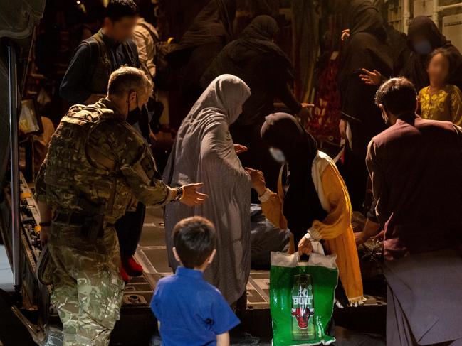 A Royal Air Force member assists evacuees from Afghanistan as they disembark a Royal Air Force C-130 Hercules at Australiaâs main operating base in the Middle East.  (This image has been digitally altered - privacy) *** Local Caption *** On Thursday 19 August, the second group of Australian citizens, visa holders and approved personnel from Hamid Karzai International Airport, Kabul arrived at Australiaâs main operating base in the Middle East.  The 76 passengers were transported via a UK Royal Air Force C-130 Hercules aircraft to the Australian Defence Forceâs temporary evacuation handling centre before boarding a chartered aircraft bound for Perth, Western Australia.