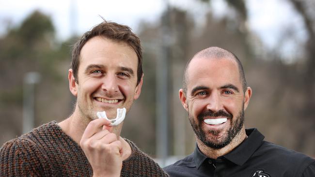 Jobe Watson, left, and Steele Sidebottom with the mouthguard technology that enables detection of concussion. Picture: David Caird