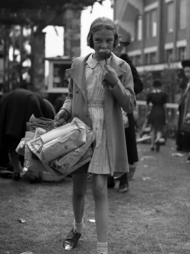 A girl enjoying a toffee apple, in 1940.