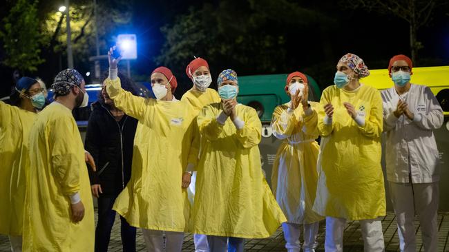 Heathcare workers acknowledge applause outside the Hospital de Barcelona. Picture: AFP.