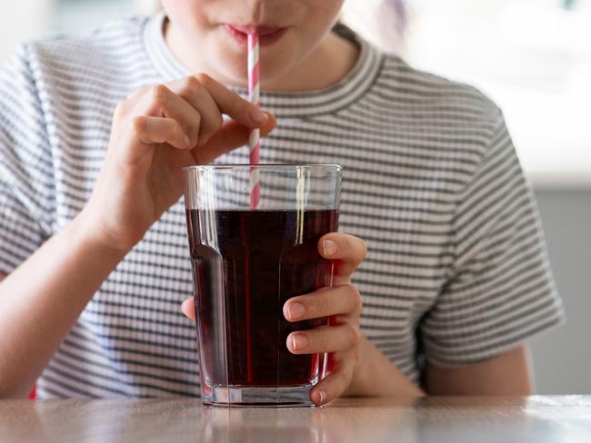 IStock generic of kids drinking -  Close Up Of Girl Drinking Sugary Fizzy Soda From Glass With Straw