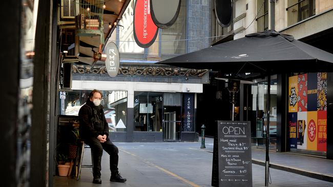 Allan King of Degraves Street’s The Quarter cafe watches on as the usually bustling eatery lane is all but deserted. Picture: NCA NewsWire/Andrew Henshaw