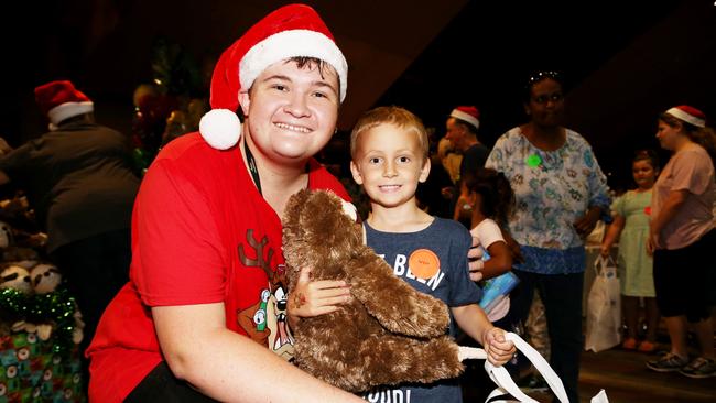 Volunteer Michael Kitto gives Chace Lock, 6, of Woree a sloth teddy in the Toy Shop at the annual Special Children's Christmas Party held at the Cairns Convention Centre. PICTURE: STEWART MCLEAN