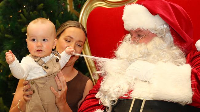 Frankie Briggs grabs a piece of Santa during photo session at Westfield Geelong. Picture: Alison Wynd