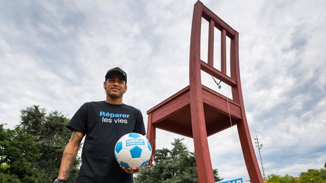 Brazilian superstar and world's most expensive footballer Neymar poses before shooting a ball from the monumental wood sculpture "Broken Chair".