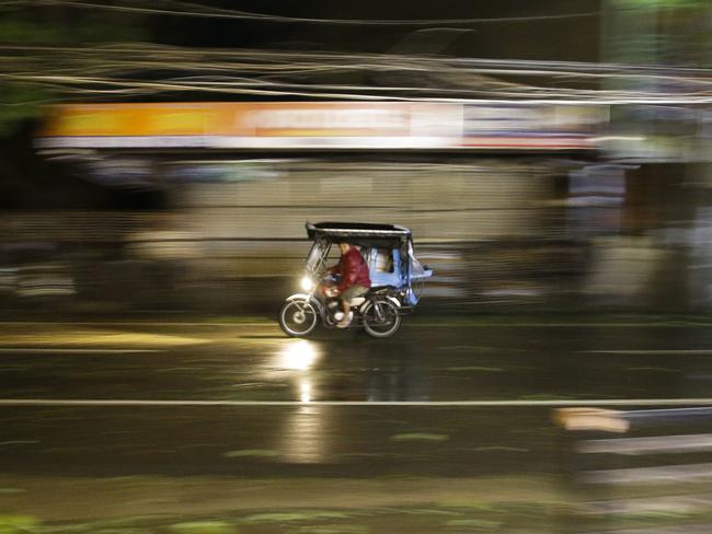 A man rides his tricycle as strong winds and rain from Typhoon Mangkhut. Picture: Aaron Favila