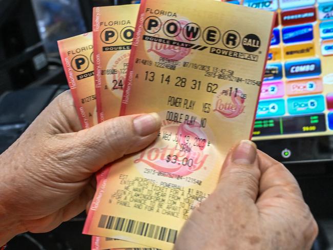 A woman holds Powerball lottery tickets inside a store in Homestead, Florida on July 19, 2023. The Powerball jackpot has reached 1 billion USD for the July 19, 2023, drawing, which has only happened two times before in the history of the game. (Photo by GIORGIO VIERA / AFP)