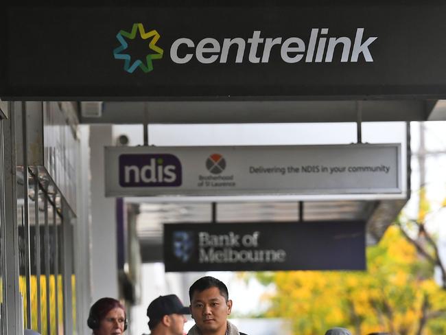 People queue up outside a Centrelink office in Melbourne on April 20, 2020, which delivers a range of government payments and services for retirees, the unemployed, families, carers and parents amongst others. - A report from the Grattan Institute predicts between 14 and 26 per cent of Australian workers could be out of work as a direct result of the coronavirus shutdown, and the crisis will have an enduring impact on jobs and the economy for years to come. (Photo by William WEST / AFP)