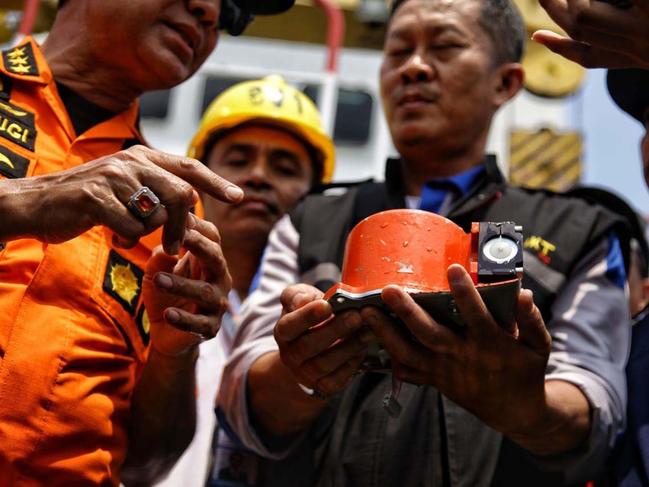 TOPSHOT - CORRECTION - This picture from Indonesia media agency "detikcom" shows officials displaying part of the ill-fated Lion Air flight JT 610's black box, an FDR (flight data recorder), after it was recovered from the Java Sea, during search operations in the waters off Karawang on November 1, 2018. - One black box from the crashed Lion Air jet has been recovered, the head of Indonesia's National Transportation Safety Committee said on November 1, which could be critical to establishing why the brand new plane fell out of the sky. (Photo by Pradita UTAMA / DETIKCOM / AFP) / “The erroneous mention[s] appearing in the metadata of this photo by Pradita UTAMA has been modified in AFP systems in the following manner: [adding Source: Indonesia media company "detikcom"]. Please immediately remove the erroneous mention[s] from all your online services and delete it (them) from your servers. If you have been authorized by AFP to distribute it (them) to third parties, please ensure that the same actions are carried out by them. Failure to promptly comply with these instructions will entail liability on your part for any continued or post notification usage. Therefore we thank you very much for all your attention and prompt action. We are sorry for the inconvenience this notification may cause and remain at your disposal for any further information you may require.”