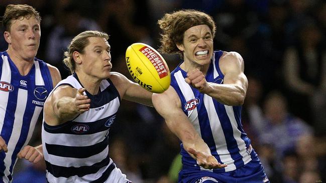 Ben Brown handballs in front of Mark Blicavs. Picture: AAP