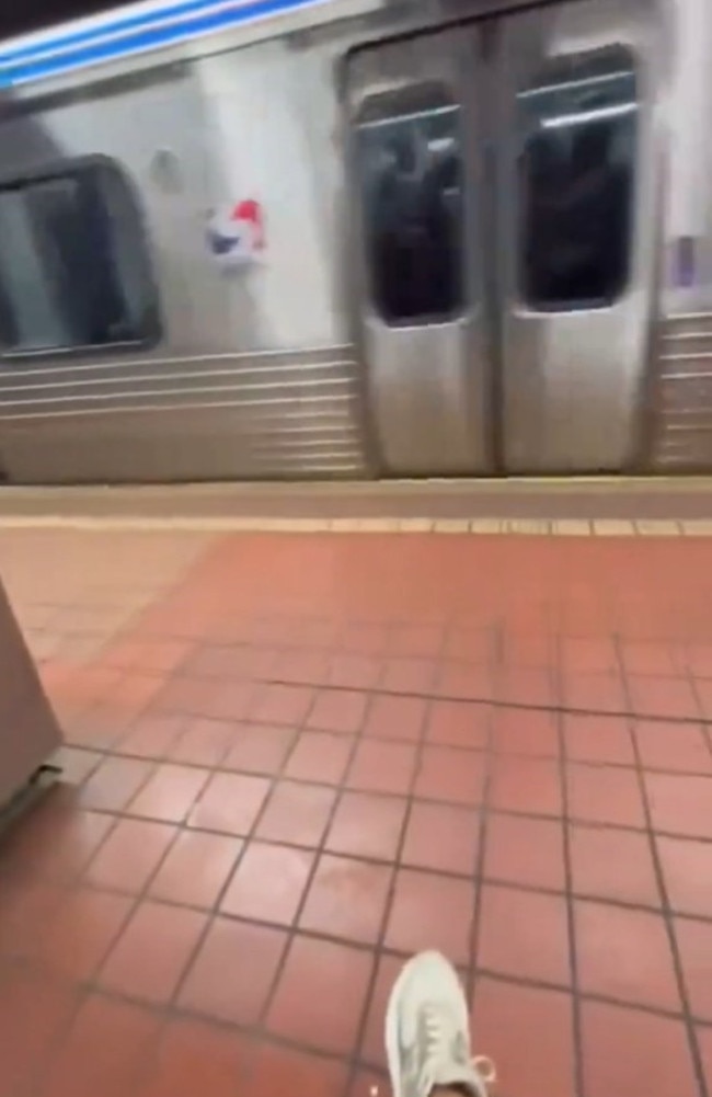 Seconds after the man falls onto the tracks, the train pulls into the station.