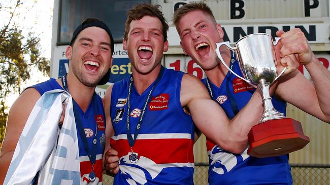 Jarrod Bayliss (middle) and Michael Fowkes (right) celebrate Wandin’s 2015 Premier Division grand final win. Picture: Colleen Petch