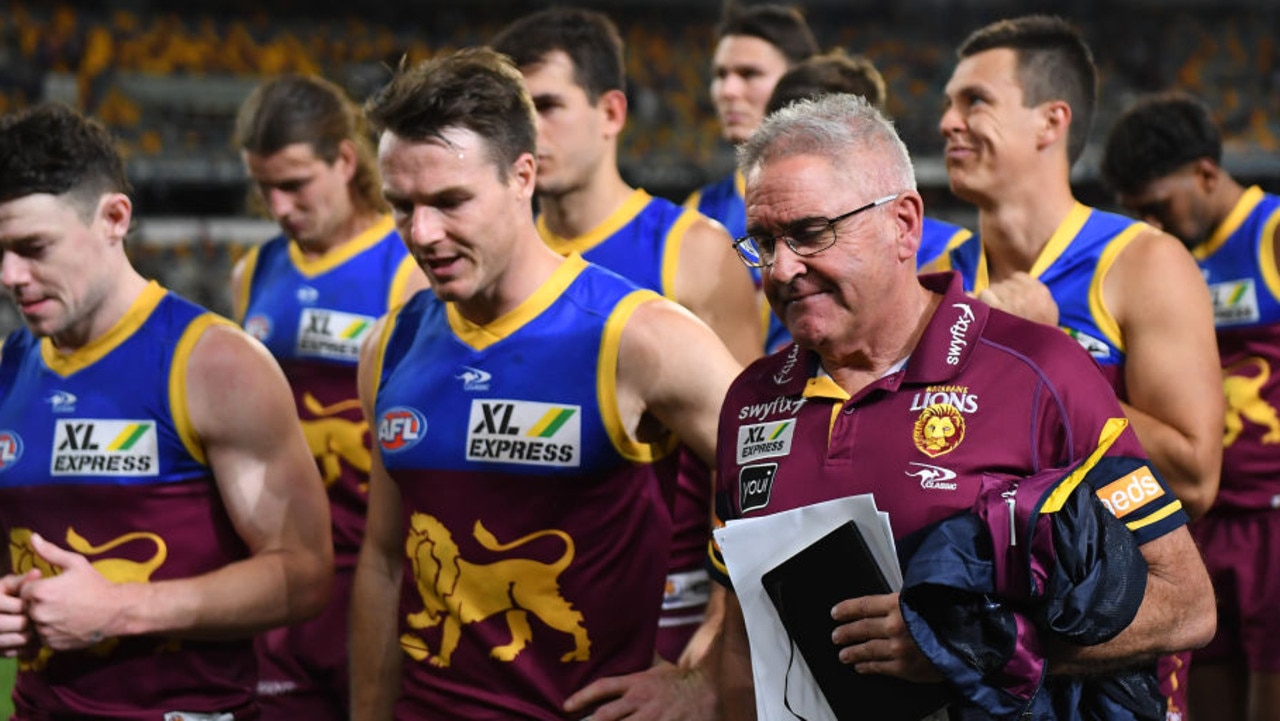 BRISBANE, AUSTRALIA - AUGUST 19: Brisbane Lions players and coach Chris Fagan walk off the field after their defeat during the round 23 AFL match between the Brisbane Lions and the Melbourne Demons at The Gabba on August 19, 2022 in Brisbane, Australia. (Photo by Albert Perez/AFL Photos via Getty Images)