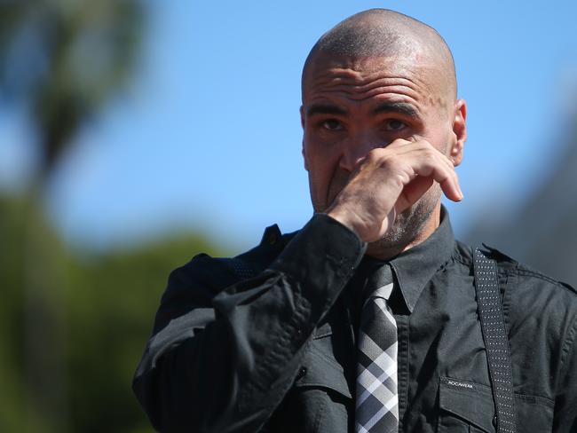 Mundine watches a video tribute at his farewell media conference.