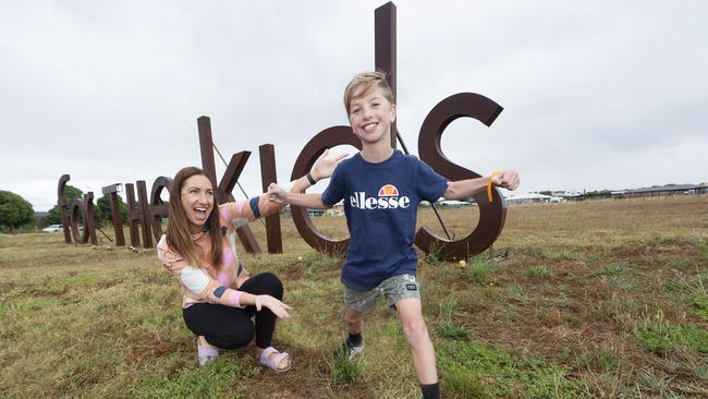 Sam Gellie and mum Amy with the Villawood letters spelling out "for the kids". Picture: Alan Barber