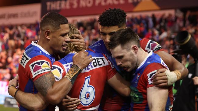 James Schiller of the Knights (right) celebrates a try with teammates in Thursday night’s thrilling match against Manly at McDonald Jones Stadium. Picture: Getty Images