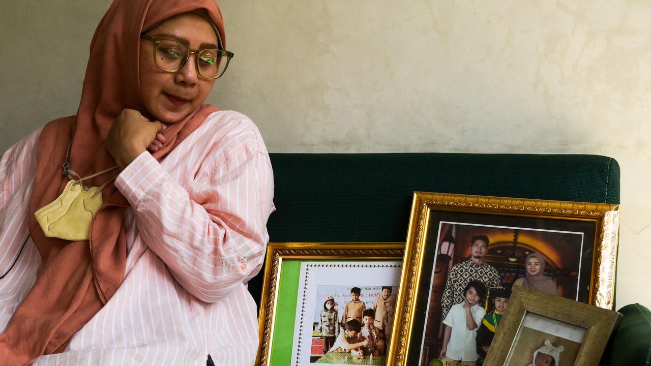 Safitri Puspa Rani shows picture frames bearing the image of her late son Panghegar Bhumi. Picture: AFP