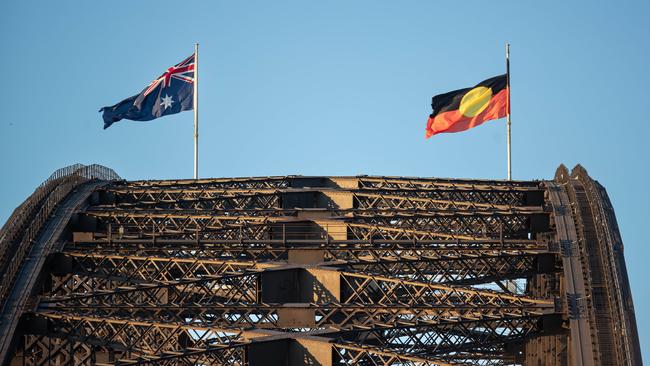 14/10/23. The Sunday Telegraph,  News,CBD, Sydney, NSW, Australia.As Australia prepares to vote in The Voice Referendum today, the Aboriginal Flag at the top of Sydney Harbour Bridge appears to be being flown at half mast.On closer inspection it is possibly tangled around the pole, which never usually happens.Flags are usually flown at half mast as a sign of mourning Ã. Perhaps natureÃs way of predicting the result of todayÃs vote.Picture: Julian Andrews