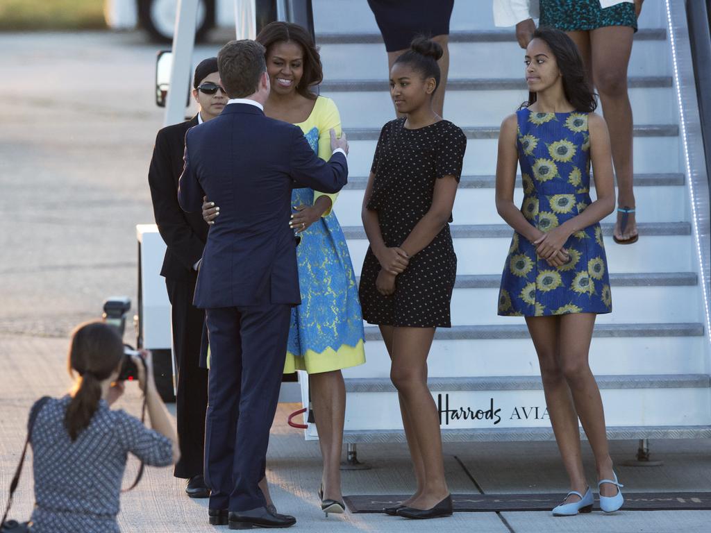 U.S. first lady Michelle Obama, her daughters Malia, right, and Natasha, center, are greeted by U.S, ambassador to the UK Matthew Barzun, left, as they disembark from a plane upon their arrival at Stansted Airport in Stansted, England, Monday, June 15, 2015. Michelle Obama is due to meet with female students in London on Tuesday to encourage them to pursue top educational goals. (AP Photo/Matt Dunham)