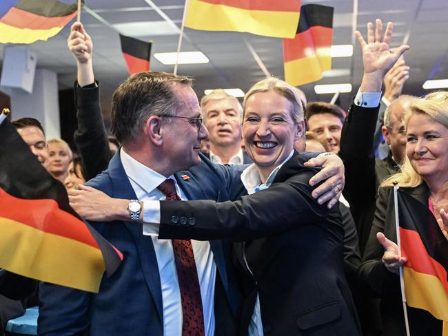 TOPSHOT - Co-leader of Germany's far-right Alternative for Germany (AfD) party and her party's top candidate for Chancellor Alice Weidel and co-leader of the far-right Alternative for Germany (AfD) party Tino Chrupalla (L) hug during the electoral evening in Berlin on February 23, 2025, after the first exit polls in the German general elections. (Photo by Soeren STACHE / POOL / AFP)