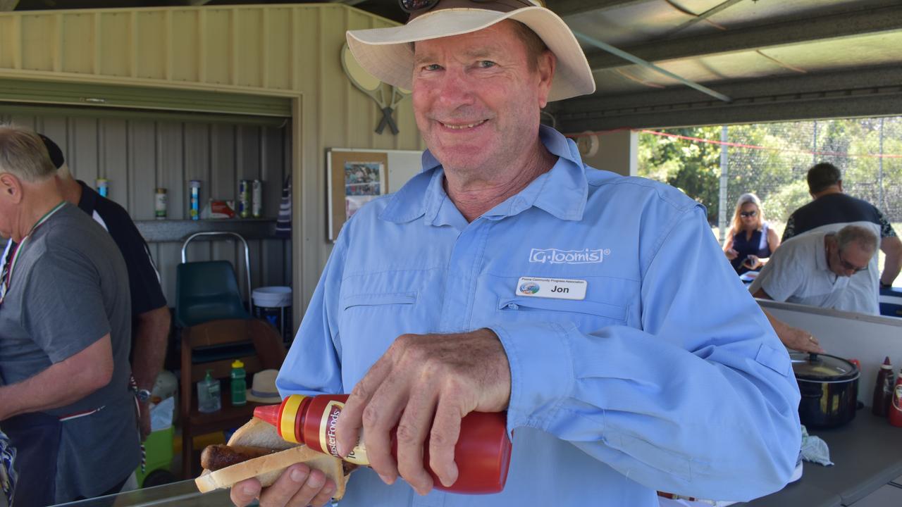 Poona Progress Association president Jon Cloclough prepares a sausage on bread at Poona's 2021 Australia Day celebrations. Photo: Stuart Fast