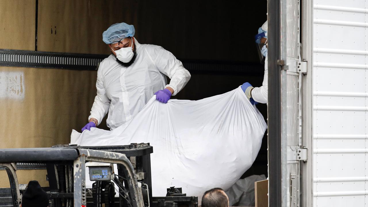 Refrigerated trucks are being used as makeshift morgues as the city struggles to cope with the number of deaths. Picture: John Minchillo/AP