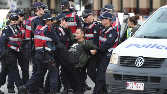 A protester is removed from a Melbourne intersection yesterday. Pictures: Tony Gough