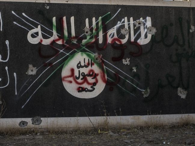 BA'AJ, IRAQ - JUNE 20: An Iraqi PMF medic takes an Islamic State sign down and places a Shia militia (PMF) in it's place, June 20, 2017 in the north-western Iraq town of Ba'aj near the Iraq-Syria border. The Popular Mobilisation Front (PMF) forces, composed of majority shiite militia, part of the Iraqi forces, have pushed Islamic State militants from the north-western Iraq border strip back into Syria. The PMF now hold the border, crucial to the fall of Islamic State in Mosul, blocking the Islamic State supply route for militants from Syria to Mosul. (Martyn Aim/Getty Images).