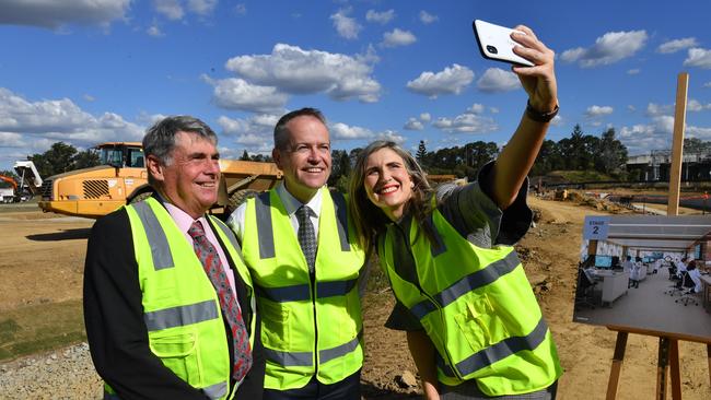 The Leader of the Opposition, Bill Shorten (centre) posing for a selfie photograph with Moreton Bay Regional Council Mayor Allan Sutherland (left) and Corinne Mulholland (right) at the construction site of the University of the Sunshine Coast's Moreton Bay Campus, in June 2018. (AAP Image/Darren England)