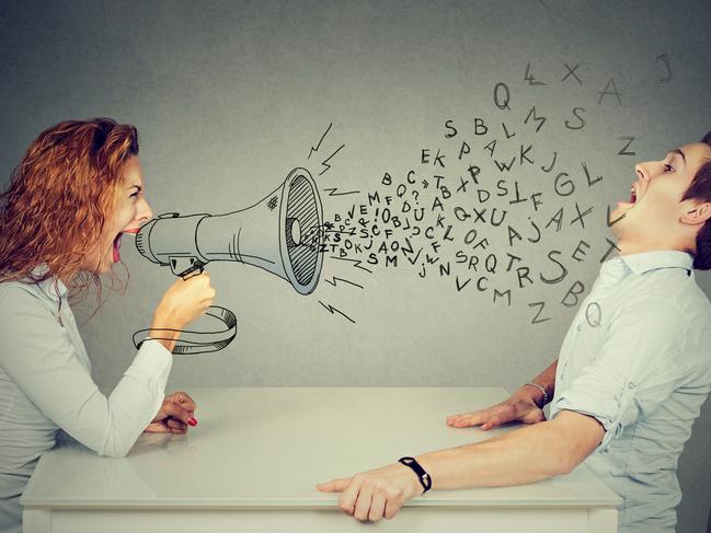 Angry young woman with megaphone shouting at stressed scared man blown away by wave of alphabet letters. Istock