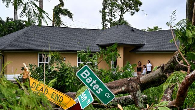 Oscar Garcia with his family stands outside his house after getting hit by a reported tornado in Fort Myers, Florida on October 9. Picture: Chandan Khana/AFP