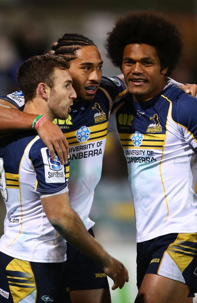 Brumbies players celebrate a try by Joe Tomane (centre).