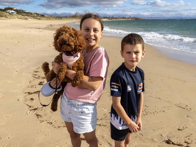 Elsie Lewis (10) with her brother Lincoln Lewis (7) with their dog Marmalade on the beach at Port Noarlunga. Picture by Kelly Barnes