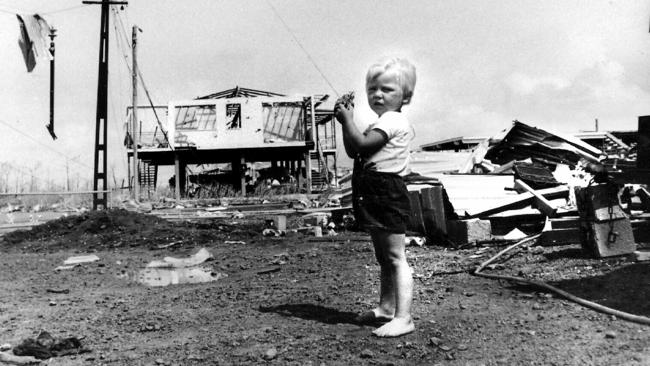 Paul Wauchope (3) flies his kite amid carnage of Cyclone Tracy in Darwin. 25/12/74.         GeneralHistorical Northern Territory / Weather / Cyclones