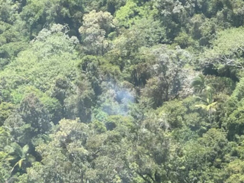 Smoke rising from the thick tree coverage of a mountain range north of Okuloo and Netherdale where it is understood a plane crashed on Saturday, October 28, 2023. Picture: RACQ CQ Rescue