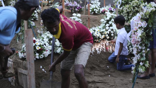 A boy lights a candle after the funeral service of Dhami Brandy, 13, who was killed during Easter Sunday's bomb blast at St. Sebastian Church, in Negombo, Sri Lanka Thursday, April 25, 2019. The U.S. Embassy in Sri Lanka warned Thursday that places of worship could be targeted for militant attacks over the coming weekend, as police searched for more suspects in the Islamic State-claimed Easter suicide bombings that killed over 350 people. (AP Photo/Manish Swarup)