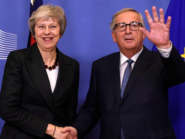 EU Commission President Jean-Claude Juncker (R) waves as he welcomes British Prime Minister Theresa May for a meeting at the EU Headquarters in Brussels on November 21, 2018. - The British Prime Minister on November 21 briefly escaped the Westminster bear pit to bring her Brexit battle to Brussels, just four days before the divorce deal is to be signed. (Photo by JOHN THYS / AFP)